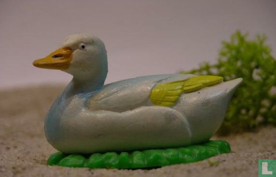 Duck lying white / yellow with grass