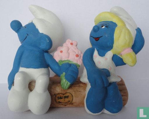 Smurf and Smurfette on tree trunk