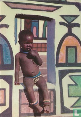 A piccanin seated on the painted wall of an 'Ndebele village - Image 1