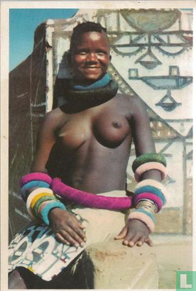 Ndebele girl besides het gaily decorated home - Image 1