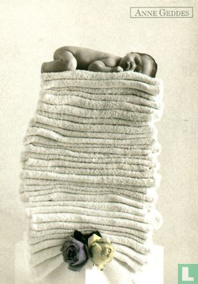 Baby slaapt op stapel handdoeken - Afbeelding 1