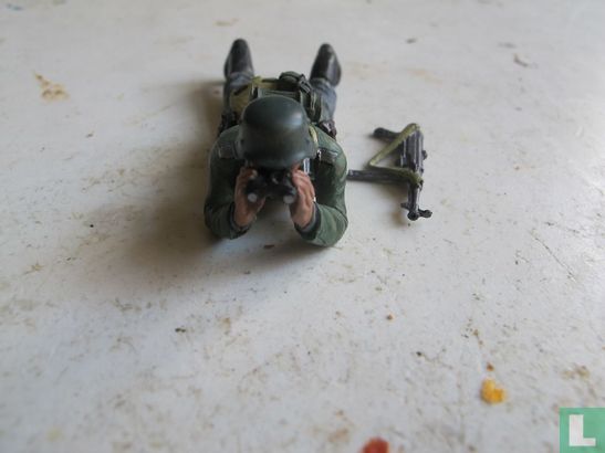 officer lying down with binoculars - Image 1