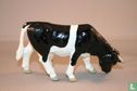 Kuh schwarz-weiß grasend - Bild 2
