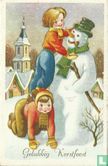 Kinderen zetten hoed op sneeuwpop - Afbeelding 1