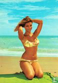 Vrouw op strand in bikini op groene handdoek - Image 1