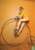 Vrouw in gele kleding op antieke fiets - Image 1