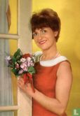 Vrouw staat bij deur - bosje bloemen in hand - Afbeelding 1