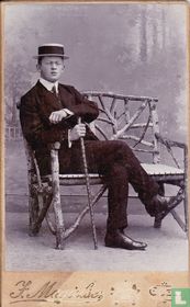 Frère, assis avec une canne, un chapeau et des lunettes