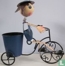 Driewieler met poppetje en bak achterop