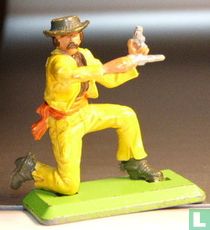 Cowboy kneeling with two guns