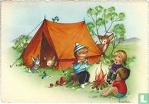 Kinderen zingen bij kampvuur voor de tent